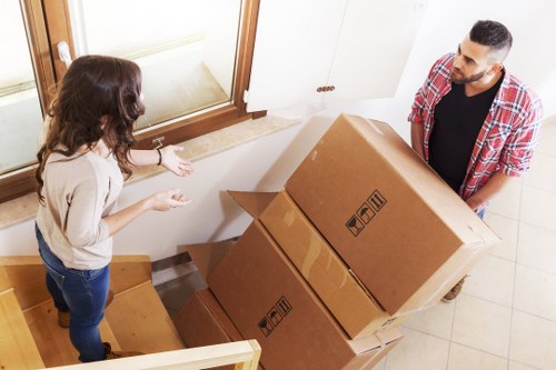 Moving team handling office boxes and workstations carefully